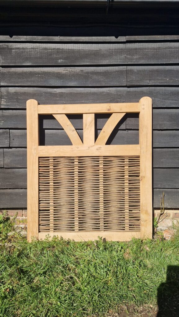 bespoke oak framed garden gate with woven willow panel complementing matching fence